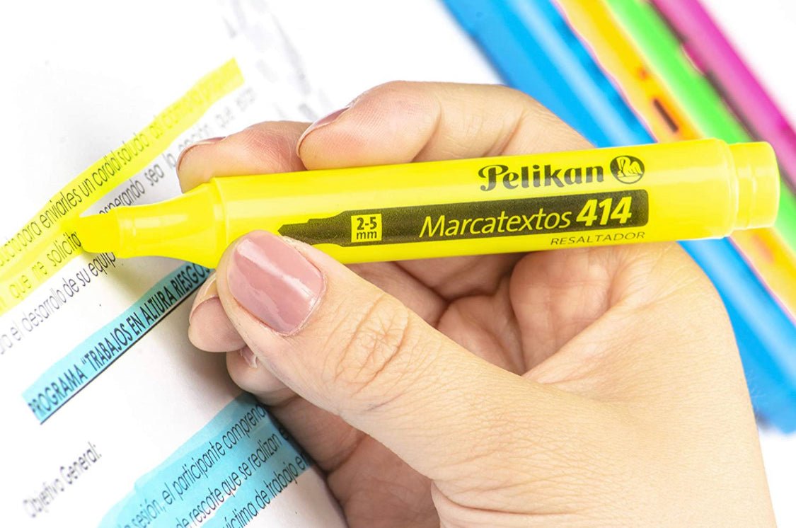 Mano resaltando texto con el resaltador Pelikan 414 amarillo sobre una hoja