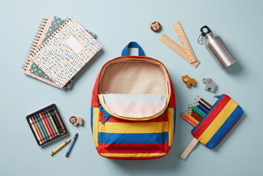 Mochila escolar colorida con útiles organizados alrededor